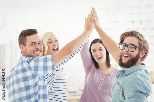 Portrait of smiling business people giving high five 