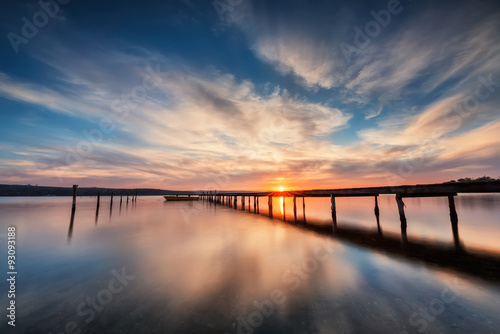 Lake sunset. Magnificent long exposure lake sunset with boat and a wooden pier © Jess_Ivanova