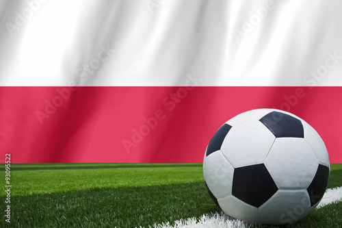 Soccer ball and national flag of Poland lies on the green grass