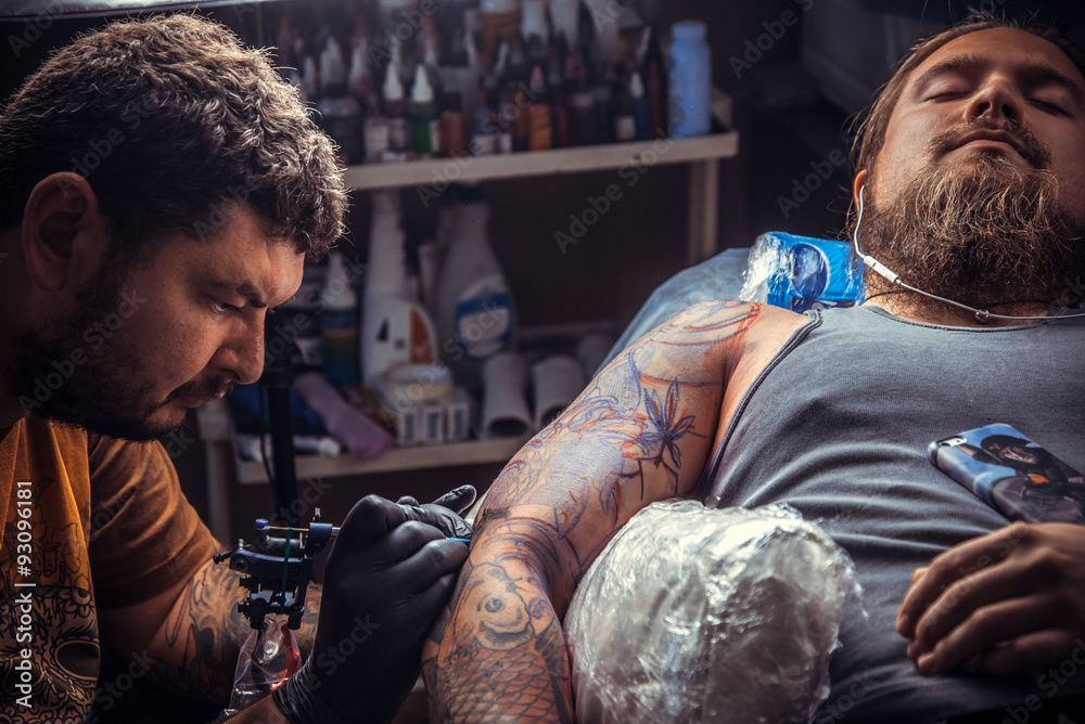 Obraz premium Tattoo artist makes a tattoo