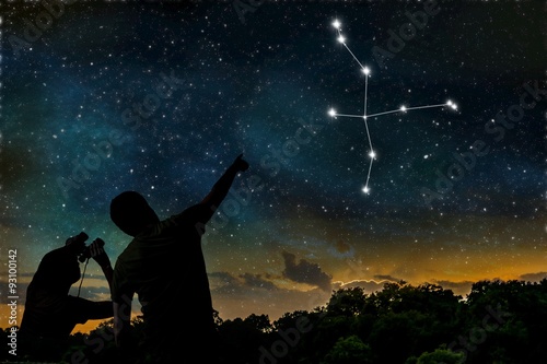 Cygnus or Swan constellation on night sky. Astrology concept. Silhouettes of adult man and child observing night sky.