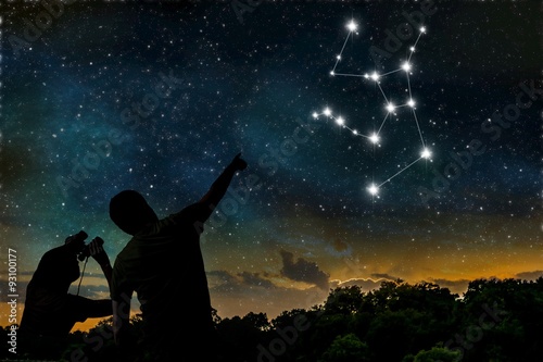 Hercules constellation on night sky. Astrology concept. Silhouettes of adult man and child observing night sky.