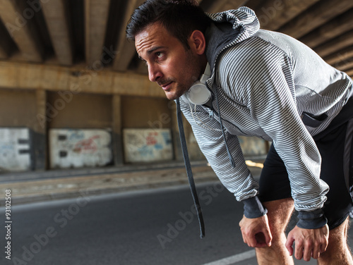 Exhausted man walking after jogging photo