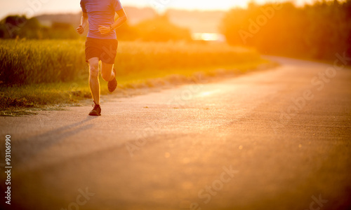 Male athlete/runner running on road