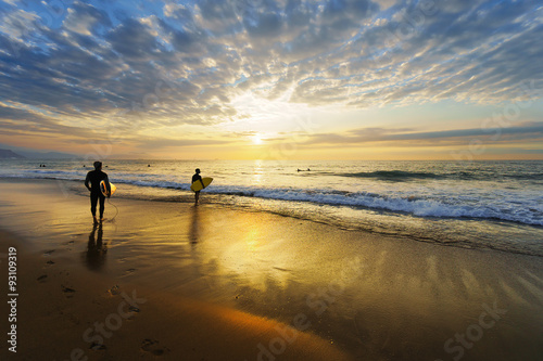 surfers entering water on Sopelana beach