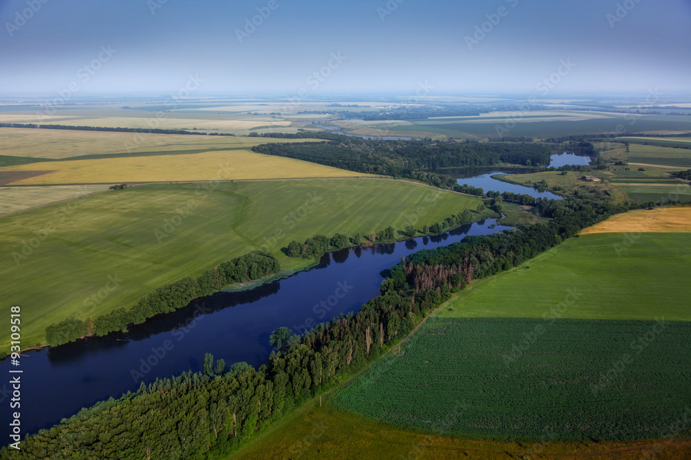 aerial view above the green fields and river