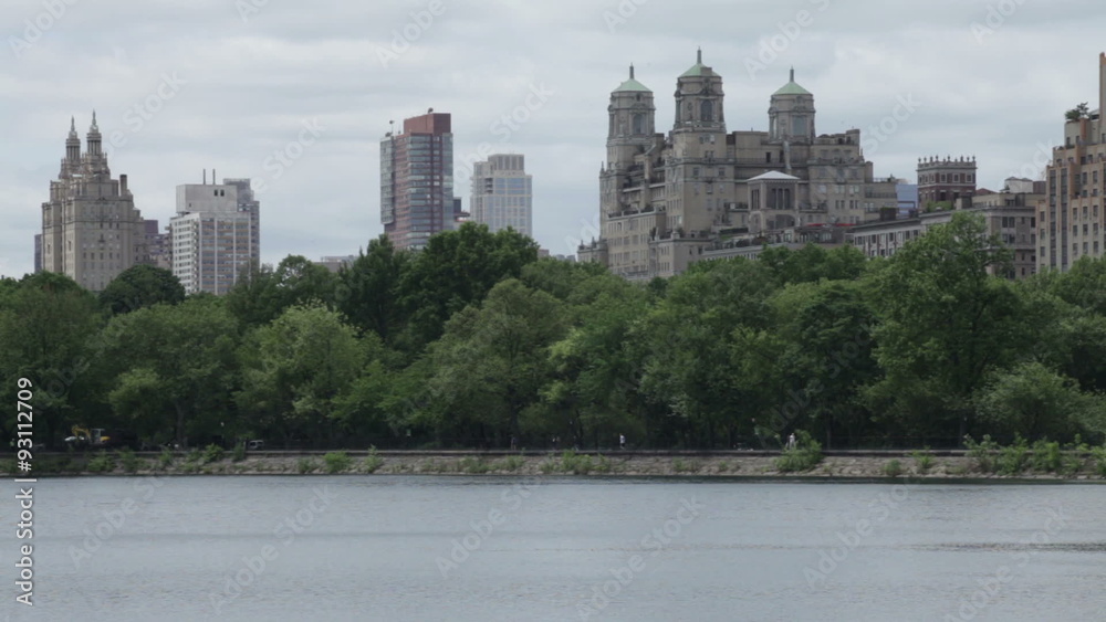 The Central Park Reservoir and Manhattan detail during cloudy spring day in New York City, USA. The Central Park Reservoir and Manhattan detail during cloudy spring day in New York City, USA.