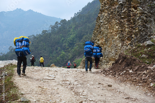 the porter is carrying stuff to trek to Poonhill  Nepal