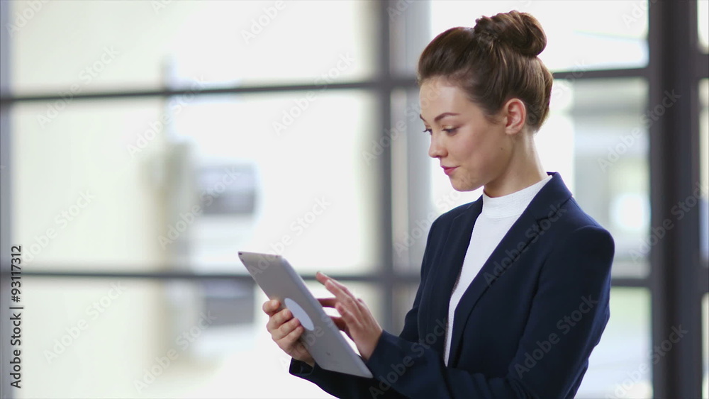Lockdown slow motion shot of businesswoman using tablet computer. Female professional is scrolling and zooming. She is in brightly lit office. Lockdown slow motion shot of businesswoman using tablet computer. Female professional is scrolling and zooming. She is in brightly lit office.