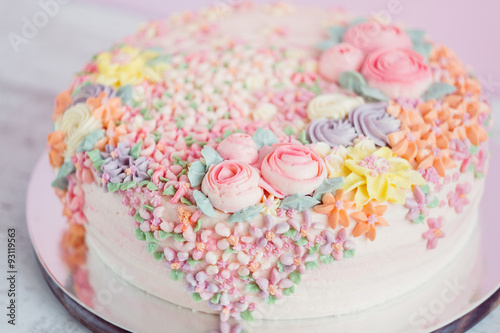 Pastel pink cake decorated with cream flowers