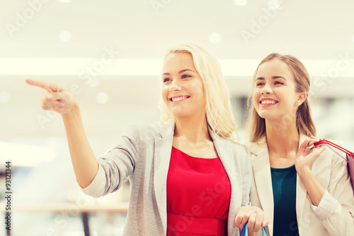 happy young women with shopping bags in mall