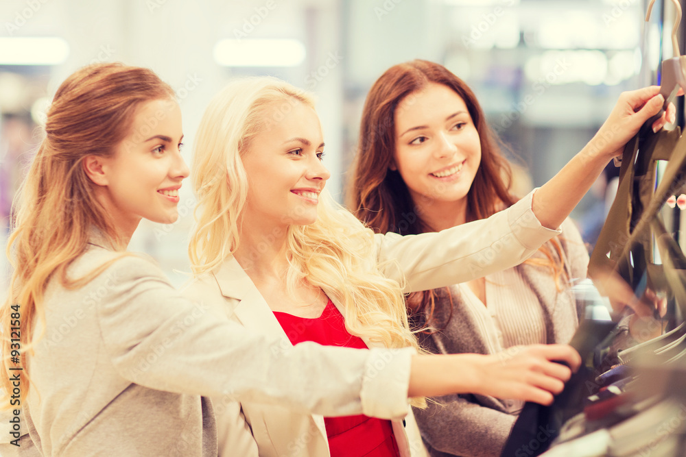 happy young women choosing clothes in mall happy young women choosing clothes in mall