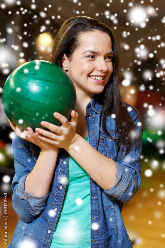 Naklejka premium happy young woman holding ball in bowling club