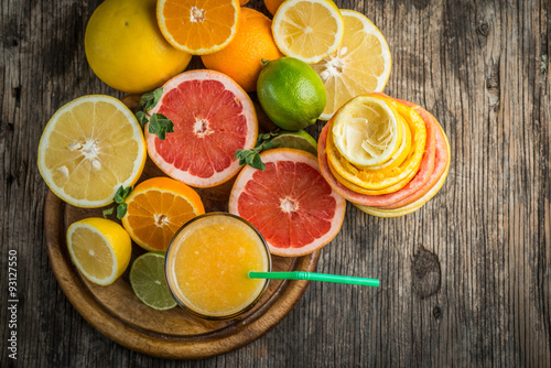 Juice glass and fresh citrus fruit on rustic wood.Fresh healthy