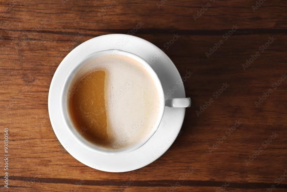 Cup of coffee with foam on wooden table, top view Cup of coffee with foam on wooden table, top view