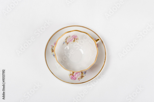 Antique porcelain tea cup with floral painting on white backgrou