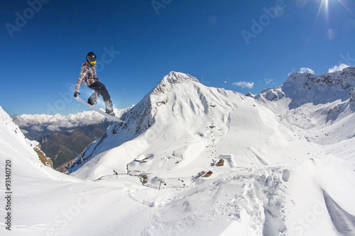 Flying snowboarder on mountains