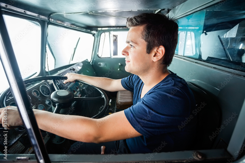 Fototapeta premium Firefighter Driving Truck At Fire Station