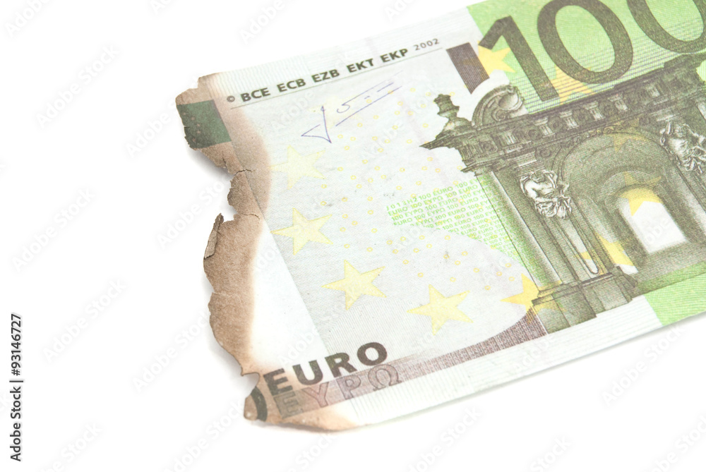 burnt bills of hundred euro on white