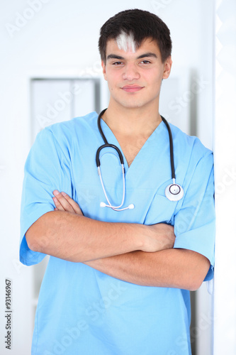 Portrait of unknown male surgeon doctor standing near the wall in hospital office, stethoscope