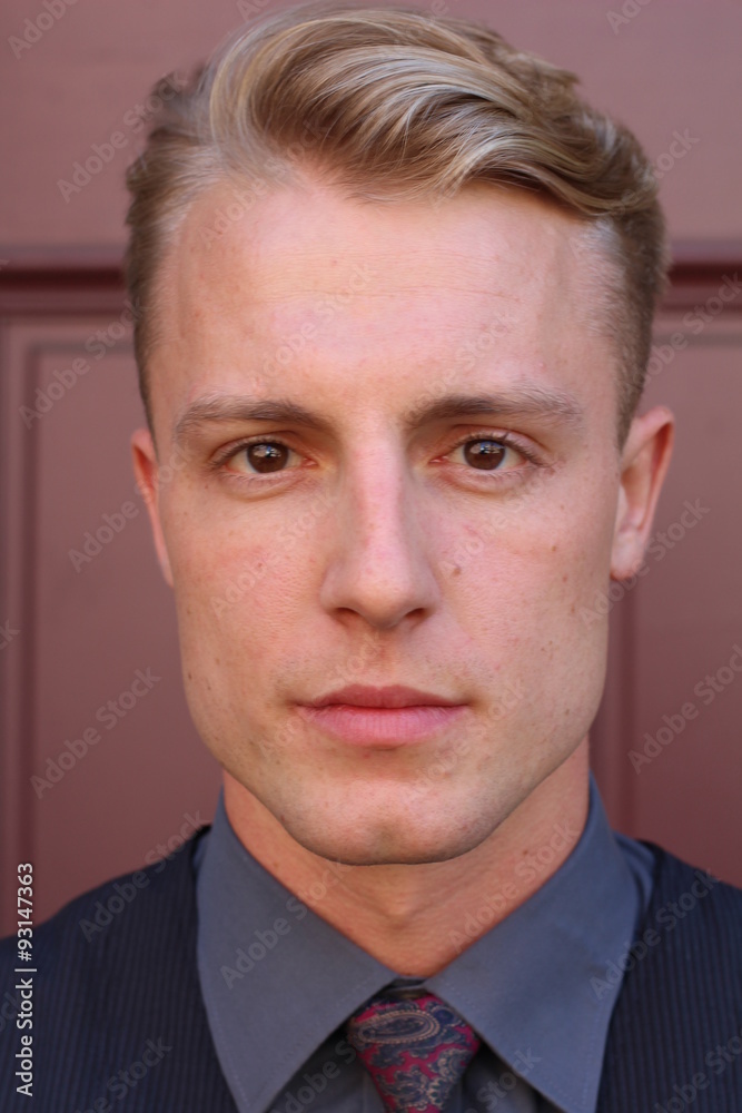 English gentleman beauty concept. Portrait of young and handsome man posing over maroon background. Close up. English gentleman beauty concept. Portrait of young and handsome man posing over maroon background. Close up.