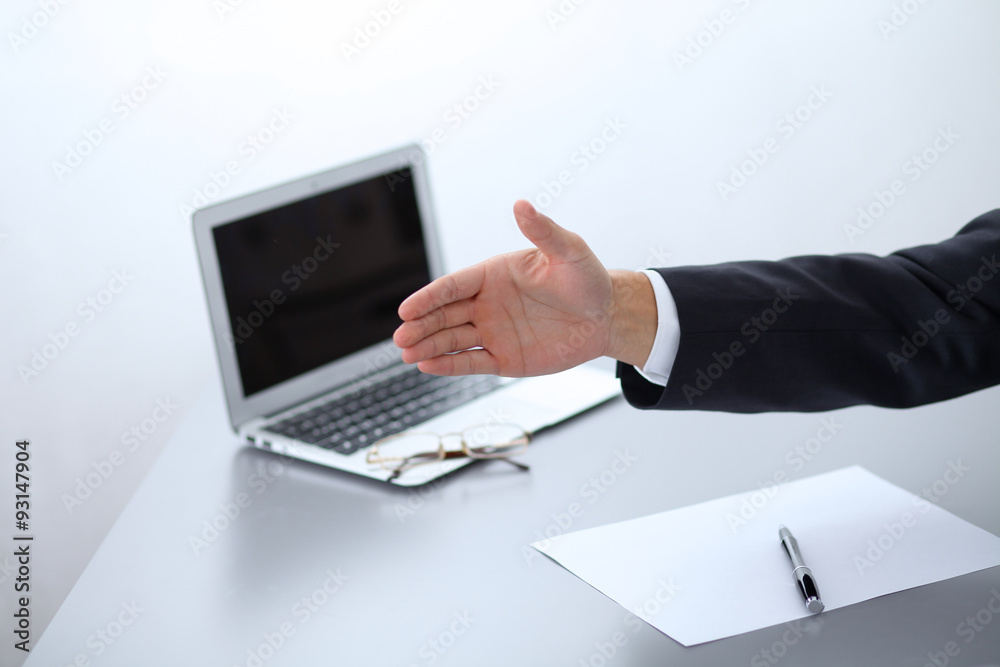 Close-up of businessman at the table giving a hand Close-up of businessman at the table giving a hand