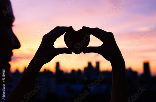 Woman holding heart in the city