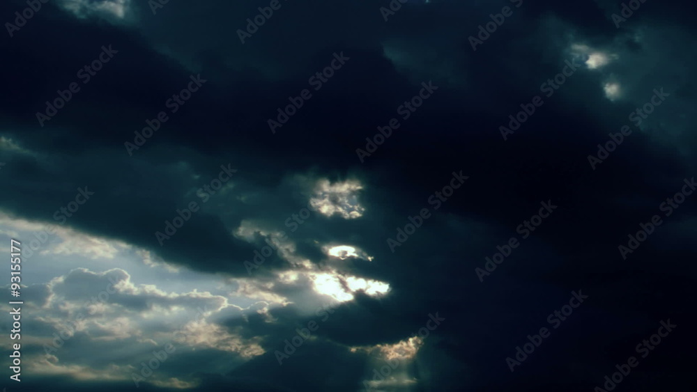 Cloud FX0312: Sunbeams shoot through thick gray and white clouds (Loop).