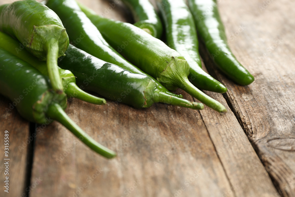 Green hot peppers on wooden table close up Green hot peppers on wooden table close up