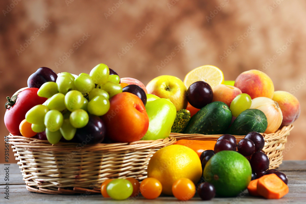Heap of fresh fruits and vegetables in basket on wooden table close up Heap of fresh fruits and vegetables in basket on wooden table close up