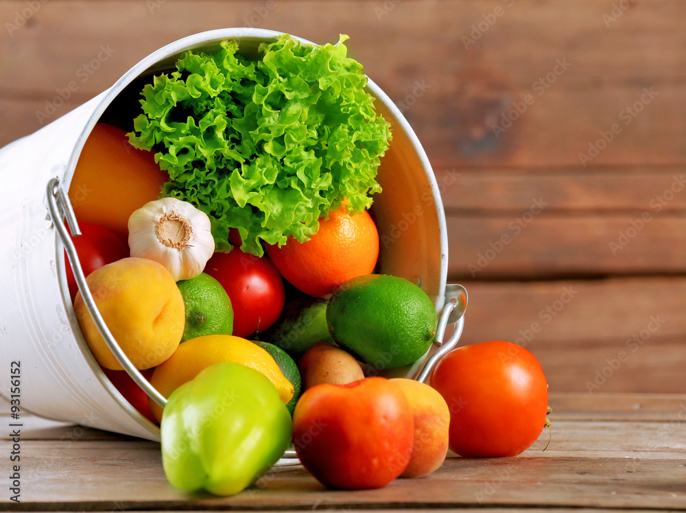 Heap of fresh fruits and vegetables in bucket on wooden table close up Heap of fresh fruits and vegetables in bucket on wooden table close up