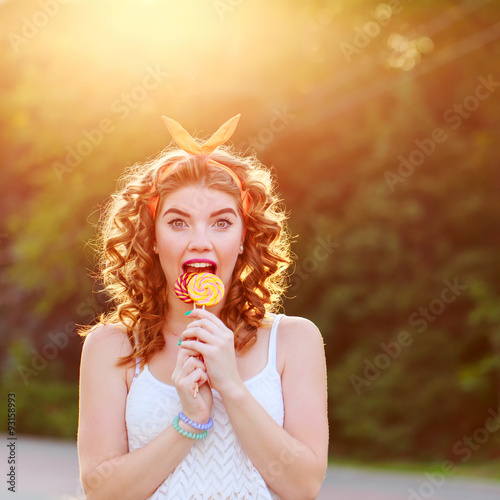 Pin Up Girl licking two lollipop.