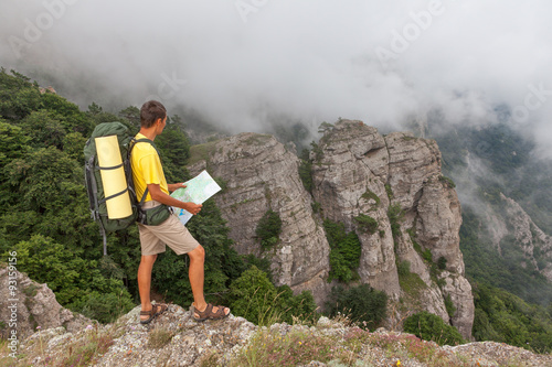 Hiker researches a way using a paper map at the mountains