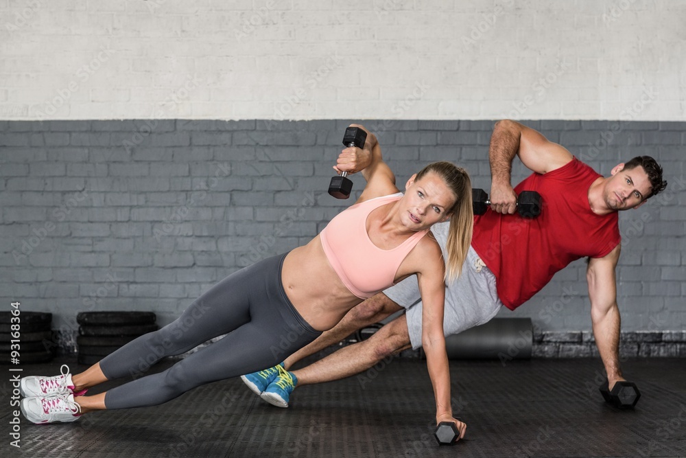 Obraz premium Fit couple doing dumbbell rows