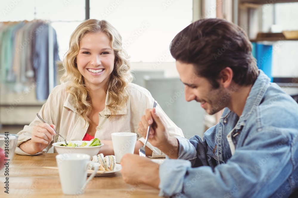 Smiling woman having breakfast with colleague in office Smiling woman having breakfast with colleague in office