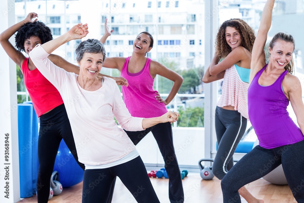 Cheerful women exercising with arms raised 