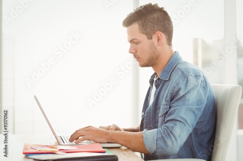 Side view of young man working on laptop 