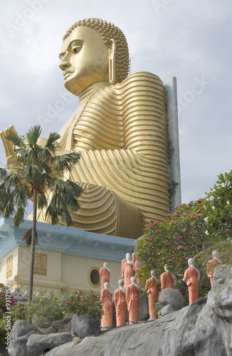 Сидящий Будда и процессия буддистских монахов. Золотой храм в Дамбулле, Шри-Ланка