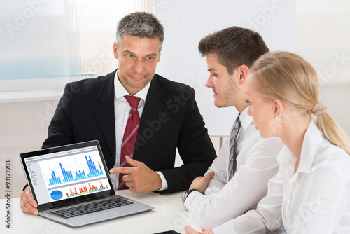 Mature Businessman Showing Graph To His Colleagues