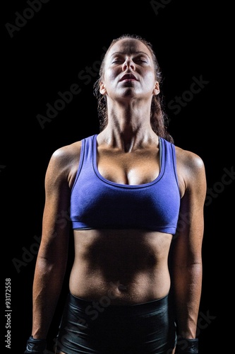 Fit woman meditating against black background © WavebreakMediaMicro