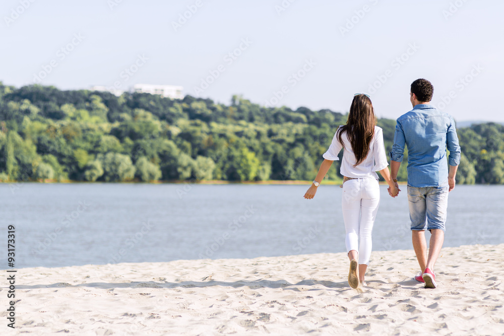 Couple holding hands and walking on a beach