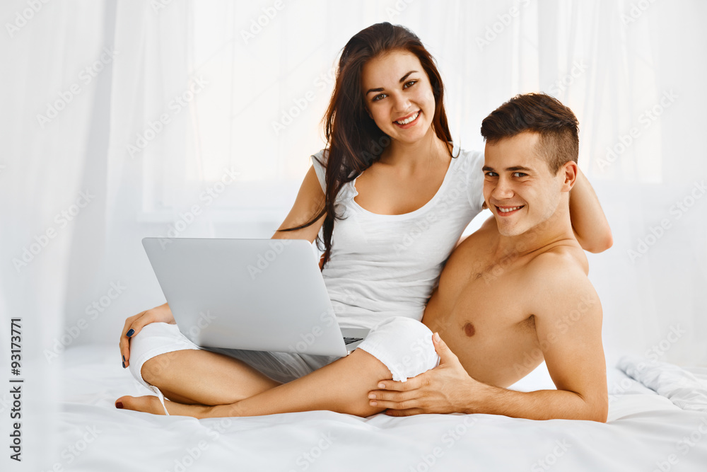 Happy couple using laptop at home Happy couple using laptop at home