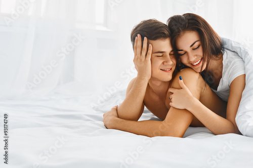 Happy man and woman in bed