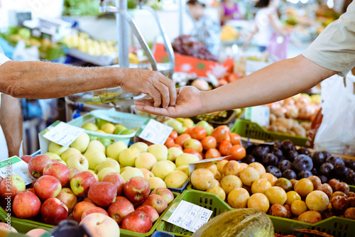 Buyer's hand and seller's hand in colorful marketplace with