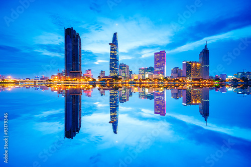 Reflection of night view of Business and Administrative Center of Ho Chi Minh city on Saigon riverbank, Vietnam. Saigon is the largest city in Vietnam with population around 10 million people.
