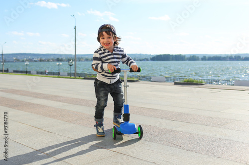 Little boy with three-wheeled scooter
