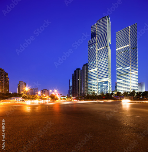 asphalt road near skyscrapers at night