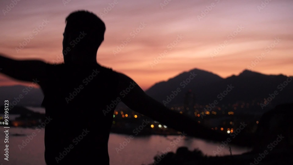 hombre bailando como un tonto en paisaje costero a contraluz