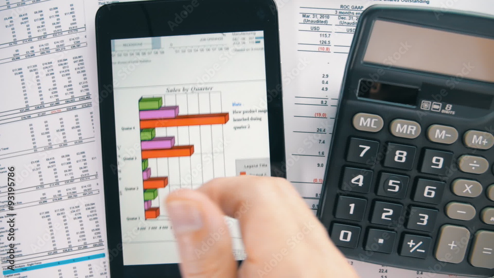 Businessman working on tablet, calculating data and calling by phone Businessman working on tablet, calculating data and calling by phone
