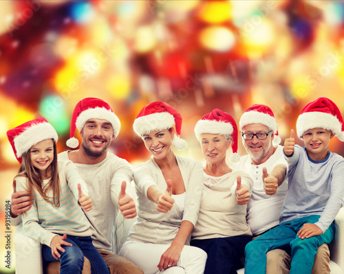 happy family in santa hats showing thumbs up
